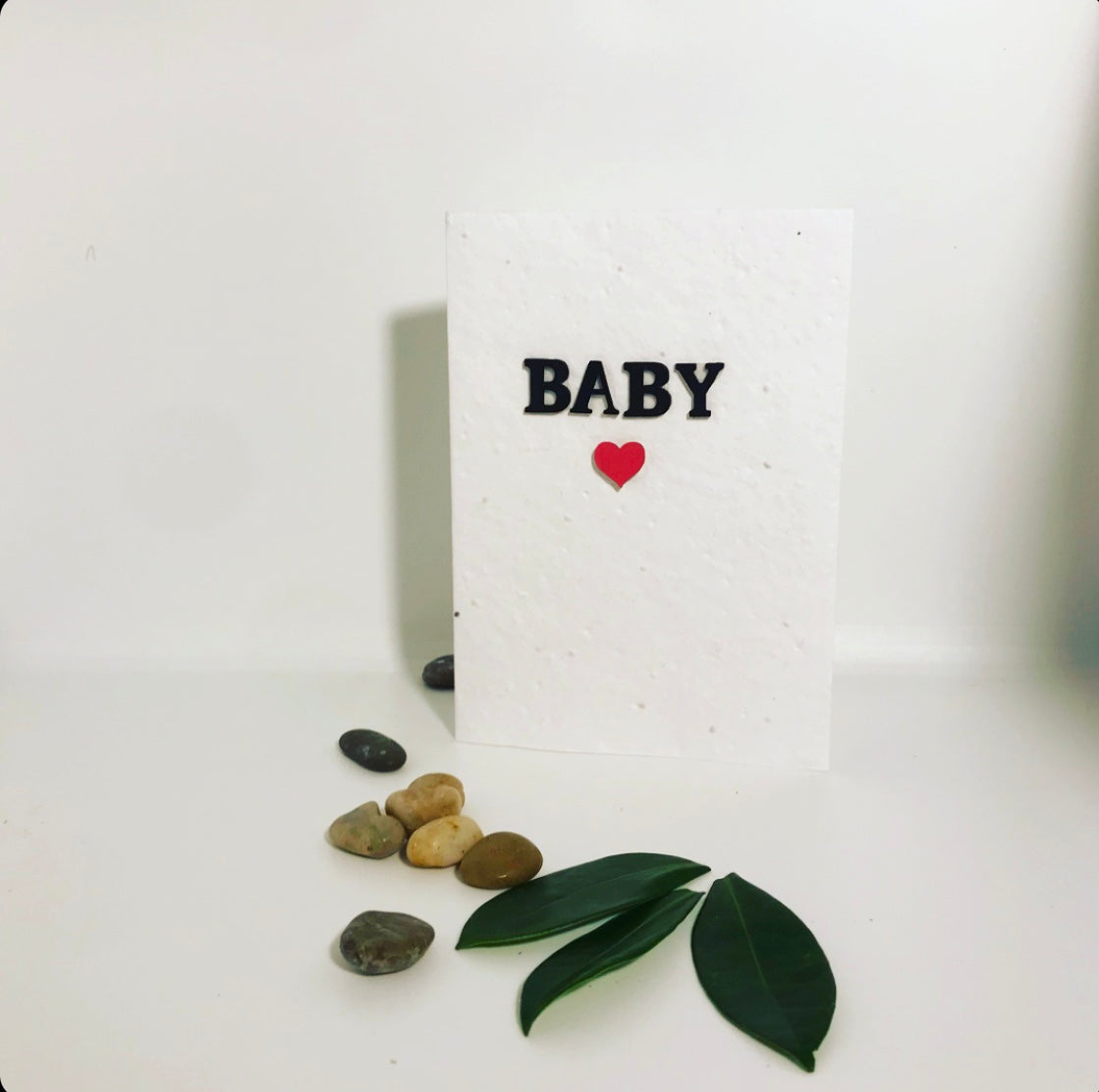 Seeded, plantable new baby card. Embellished with a black hand painted baby wording with pink, pastel heart.