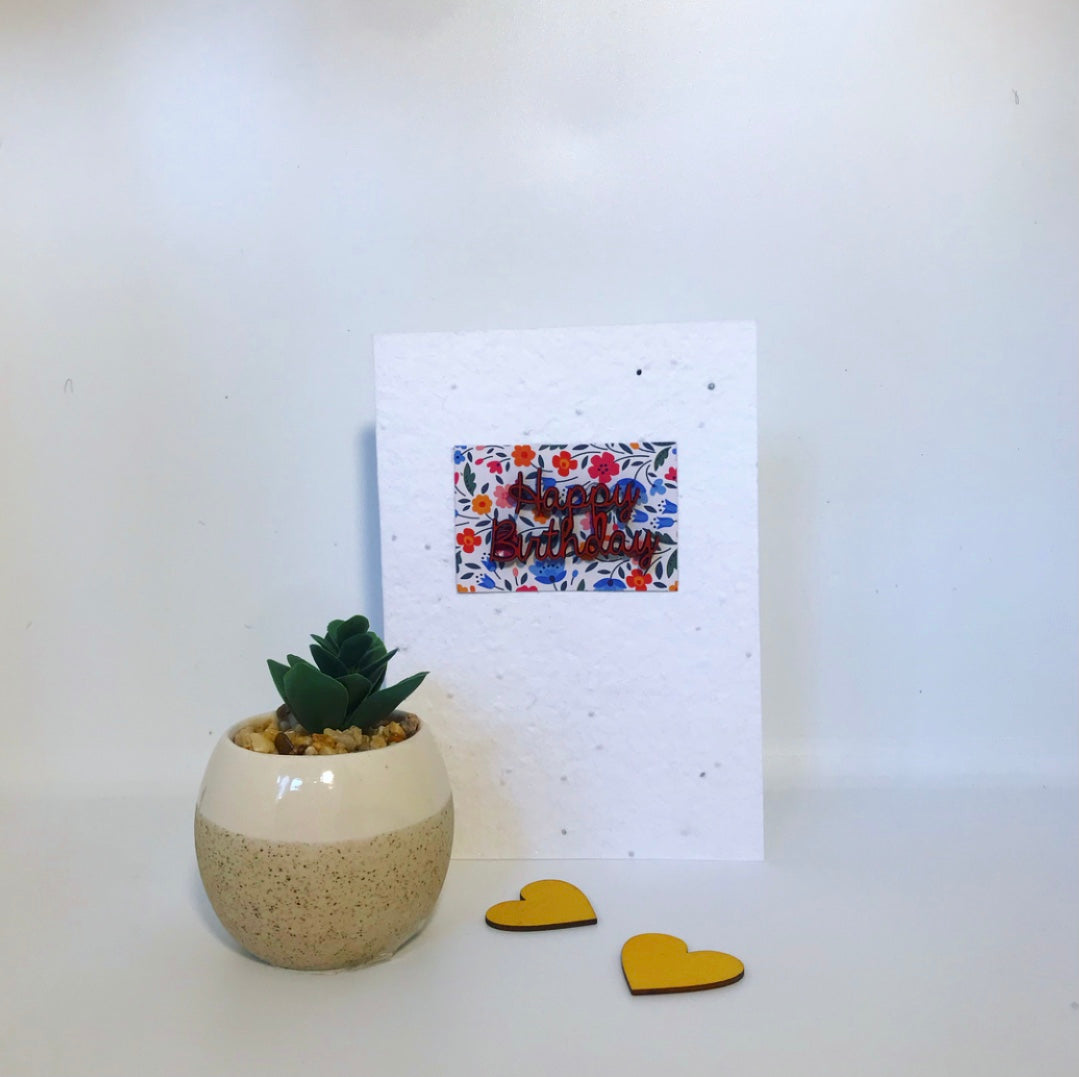 Seeded, plantable greeting card. With hand painted red, wooden happy birthday motif with floral background.