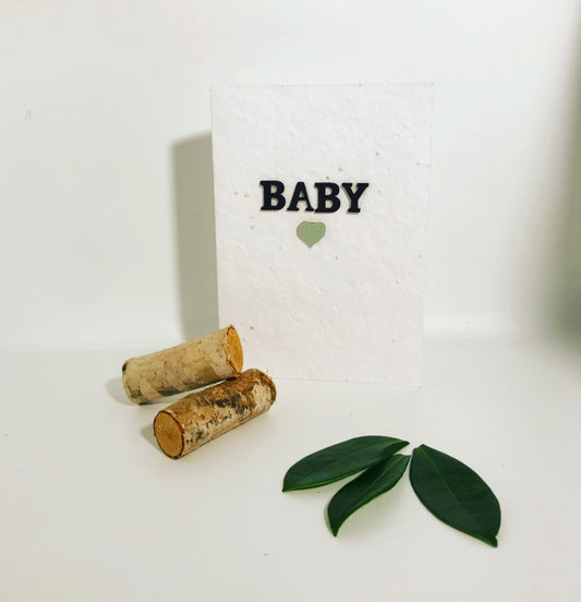 Seeded, plantable new baby card. Embellished with a black hand painted baby wording with green, pastel heart.