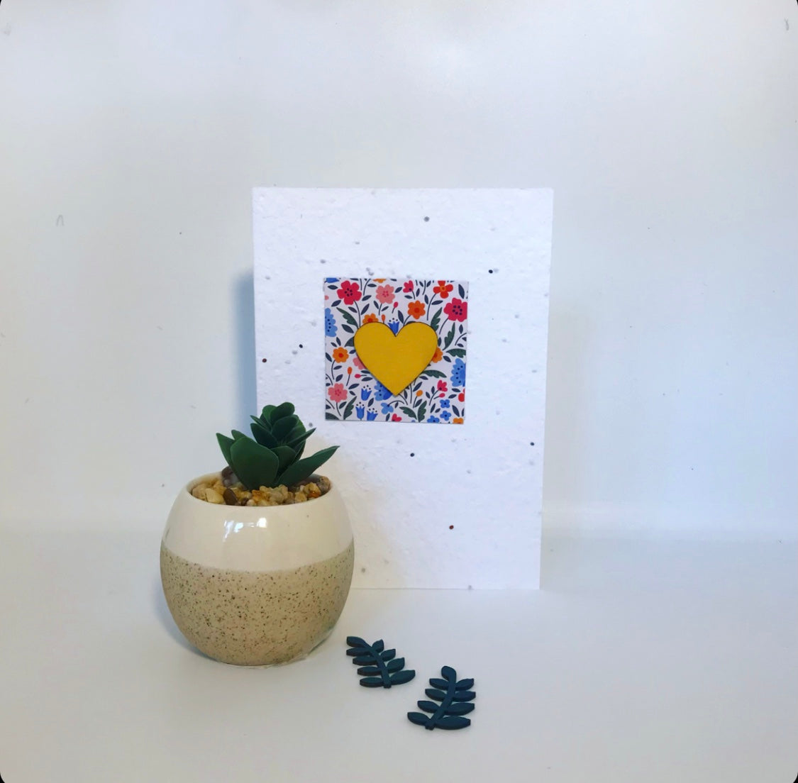 Seeded, plantable greeting card. With hand painted yellow, wooden heart motif with floral background.